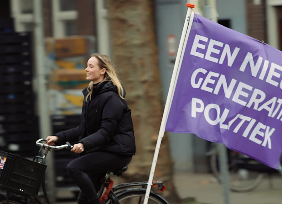 Volter riding a bike with a flag saying 