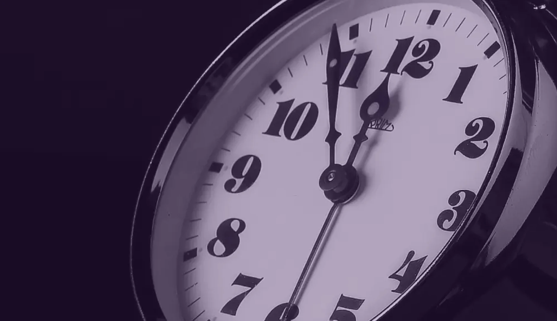Clock in purple hue ticking Five before Twelve